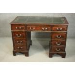 A 20th century mahogany pedestal desk, with a tooled green leather writing surface, over an