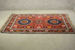 A red ground hand made Persian Kurdish rug. H.204 W.134cm.