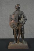 A cast iron fire companion stand in the form of a knight, holding a shield with three fleur de