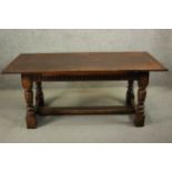 A reproduction country oak extending refectory dining table, the plank top with cleated ends and