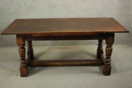 A reproduction country oak extending refectory dining table, the plank top with cleated ends and