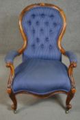 A Victorian walnut spoon back open armchair, upholstered in striped blue fabric, to the arms, seat