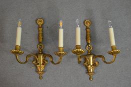 A pair of gilt metal two branch regency style wall sconces with laurel leaf and ribbon motifs. H.