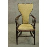 A circa 1900 open armchair, with a shaped back, and spindles to the curved arms, with yellow