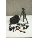 A collection of vintage camera equipment, including a Topcon camera, a tripod, lenses and other