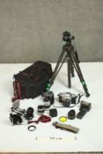 A collection of vintage camera equipment, including a Topcon camera, a tripod, lenses and other