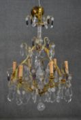 A large early 20th century gilt brass six branch chandelier with crystal flowers and swags studded