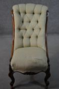 An early Victorian mahogany nursing chair, with a scrolling and buttoned back, upholstered in