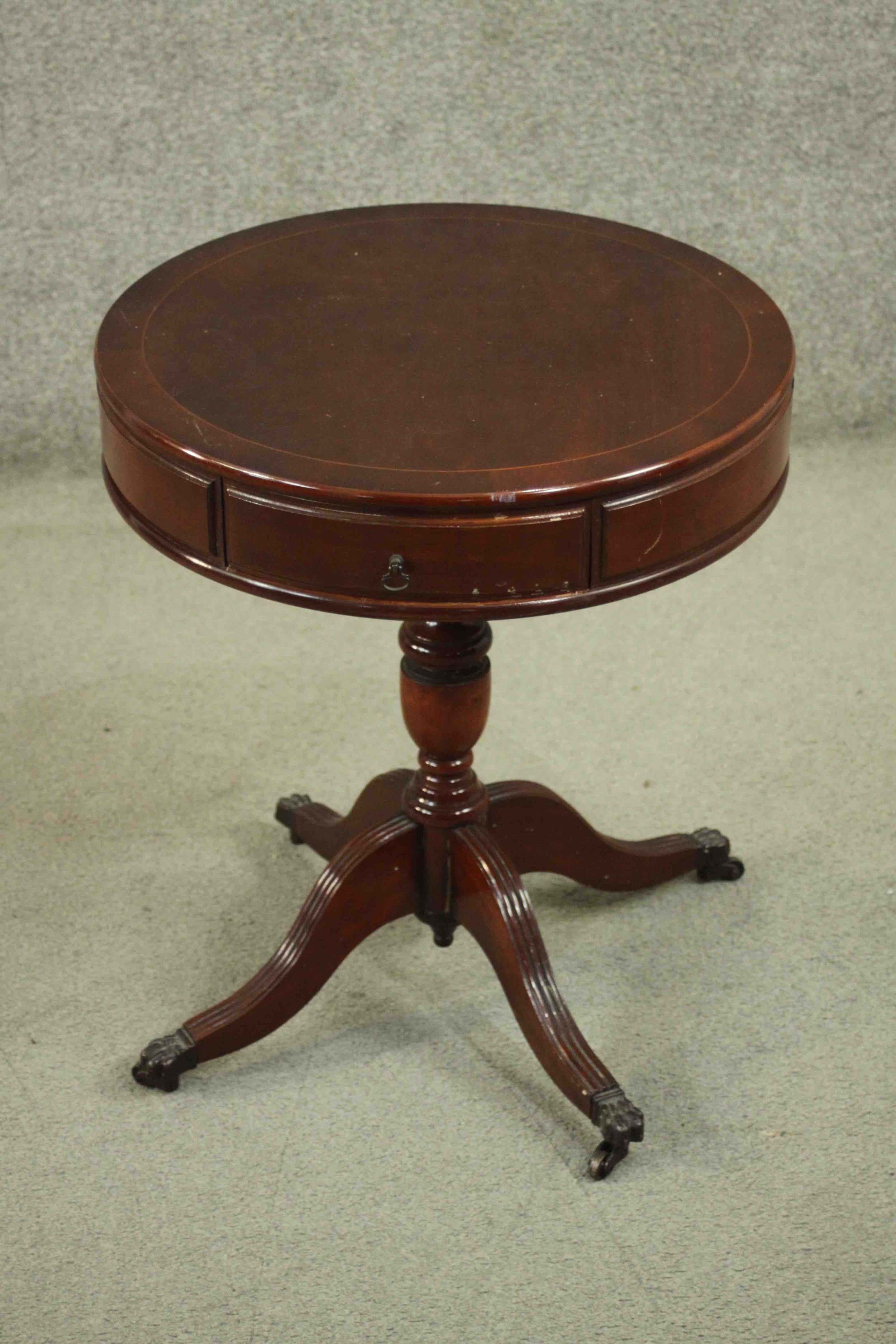 A reproduction mahogany drum occasional table, the circular top with two drawers, on a vase turned