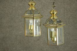 A pair of reproduction George III style brass hall lanterns, of hexagonal section, each with two
