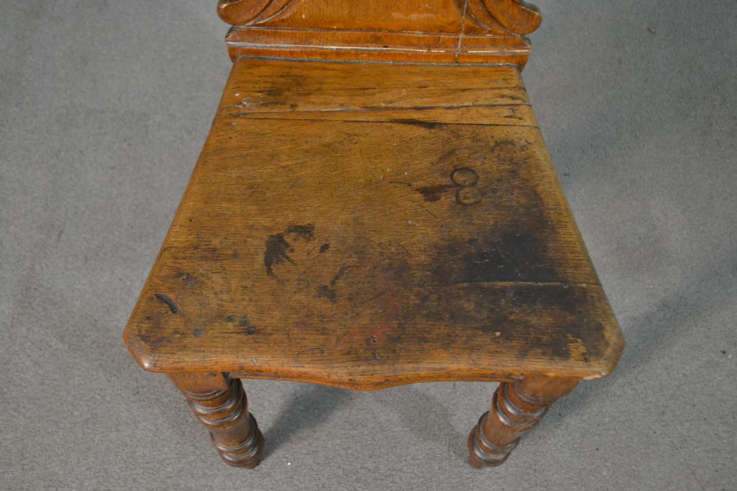 A Victorian oak hall chair, with a carved and pierced scrolling back, on turned legs. - Image 3 of 4