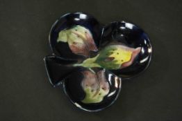 A Moorcroft pottery dish in the form of a three leaf clover with Iris pattern on a blue ground.