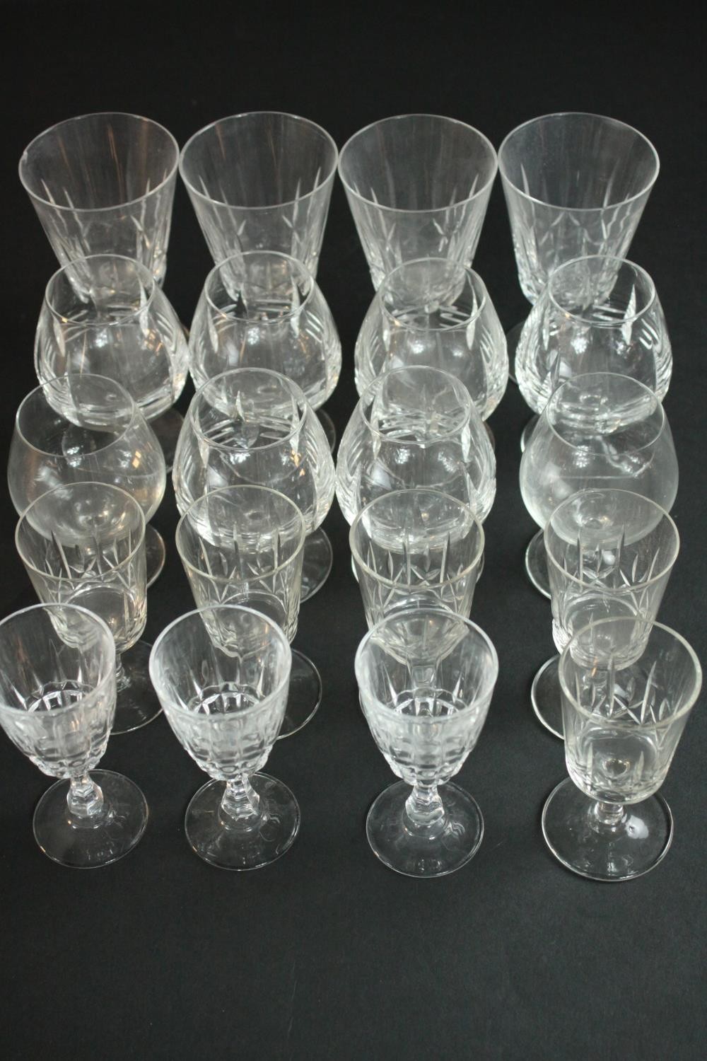 A collection of twenty alcohol glasses, including a set of six hand cut crystal brandy glasses, a