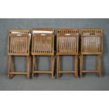 A set of four Gloster teak folding garden chairs, with slatted back and seat, with a loose