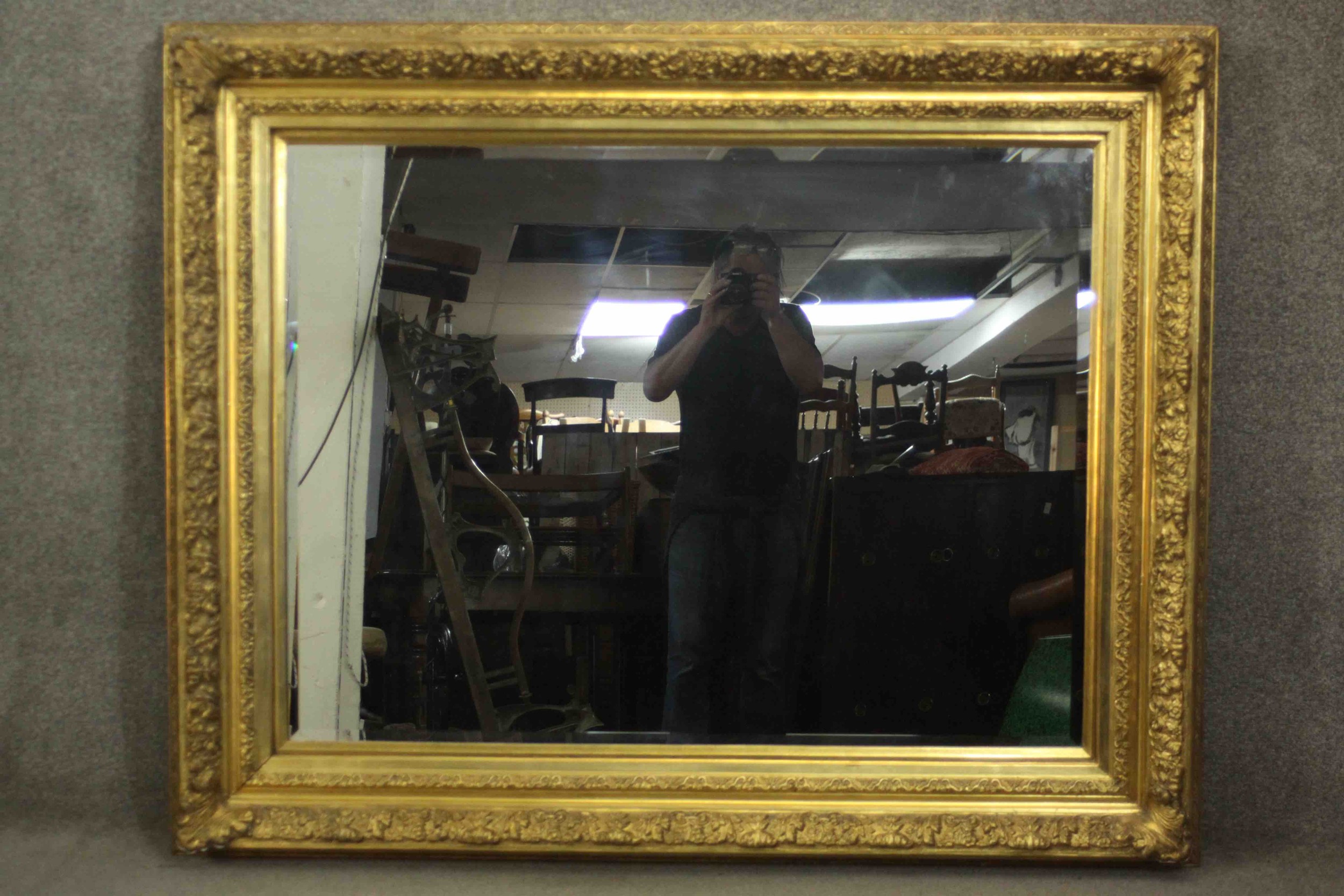 A large ornately decorated wall or pier mirror in rectangular frame with bevelled edge plate. H.