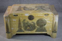 A 20th century Chinese yellow painted camphorwood trunk, decorated to the top and front wth a pagoda