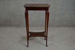 An Edwardian walnut occasional table, with a shaped rectangular top, on slender cabriole legs,