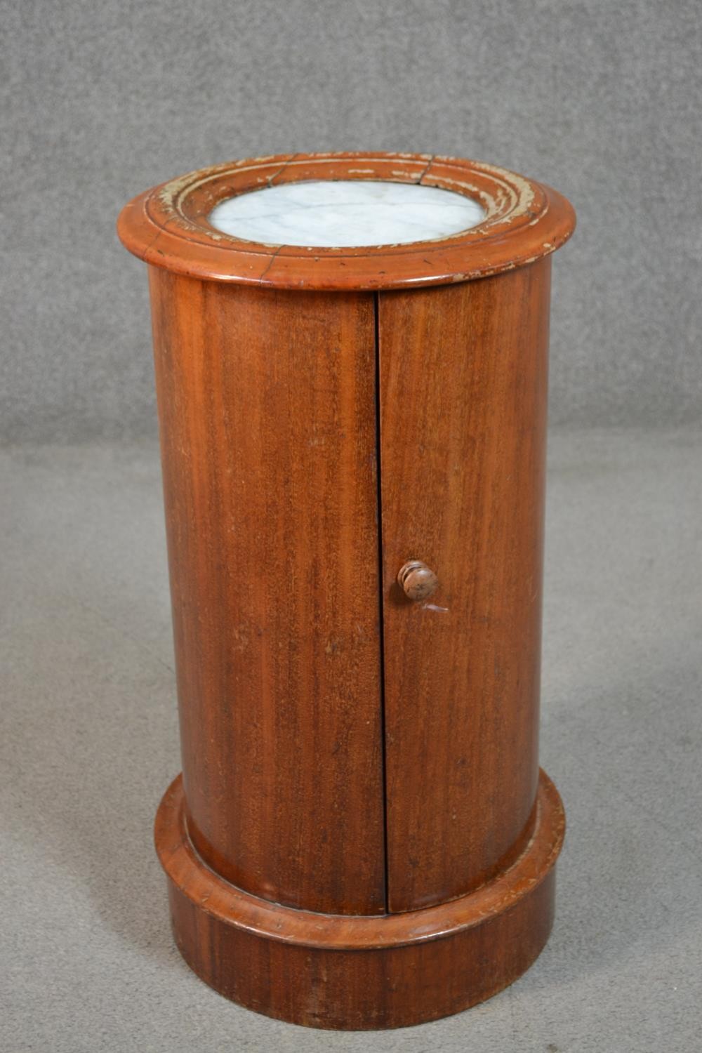 A Victorian mahogany cylindrical bedside cabinet, with an inset white marble top and moulded edge,