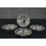 A set of four Victorian pierced repousse design silver dishes with engraved coat of arms to the