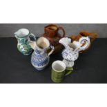 Six art pottery and ceramic jugs, including a Doulton style Tobacco jug with hunting scene. Some