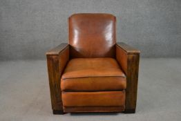 A circa 1930s design tan leather club armchair, with angular fruitwood arms, and studded borders, on