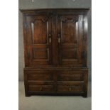 A late 17th to early 18th century oak housekeepers cupboard converted to a wardrobe, with a pair