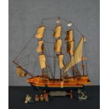 A carved and painted model of the Golden Hind, with plaque along with some figures of sailors. H.