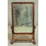 A 19th century Chinese dressing mirror on carved and pierced stand. H.82 W.53. D.23cm.