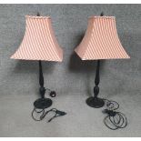 A pair of 20th century table lamps, black painted (repaired), with a red and white striped shades.
