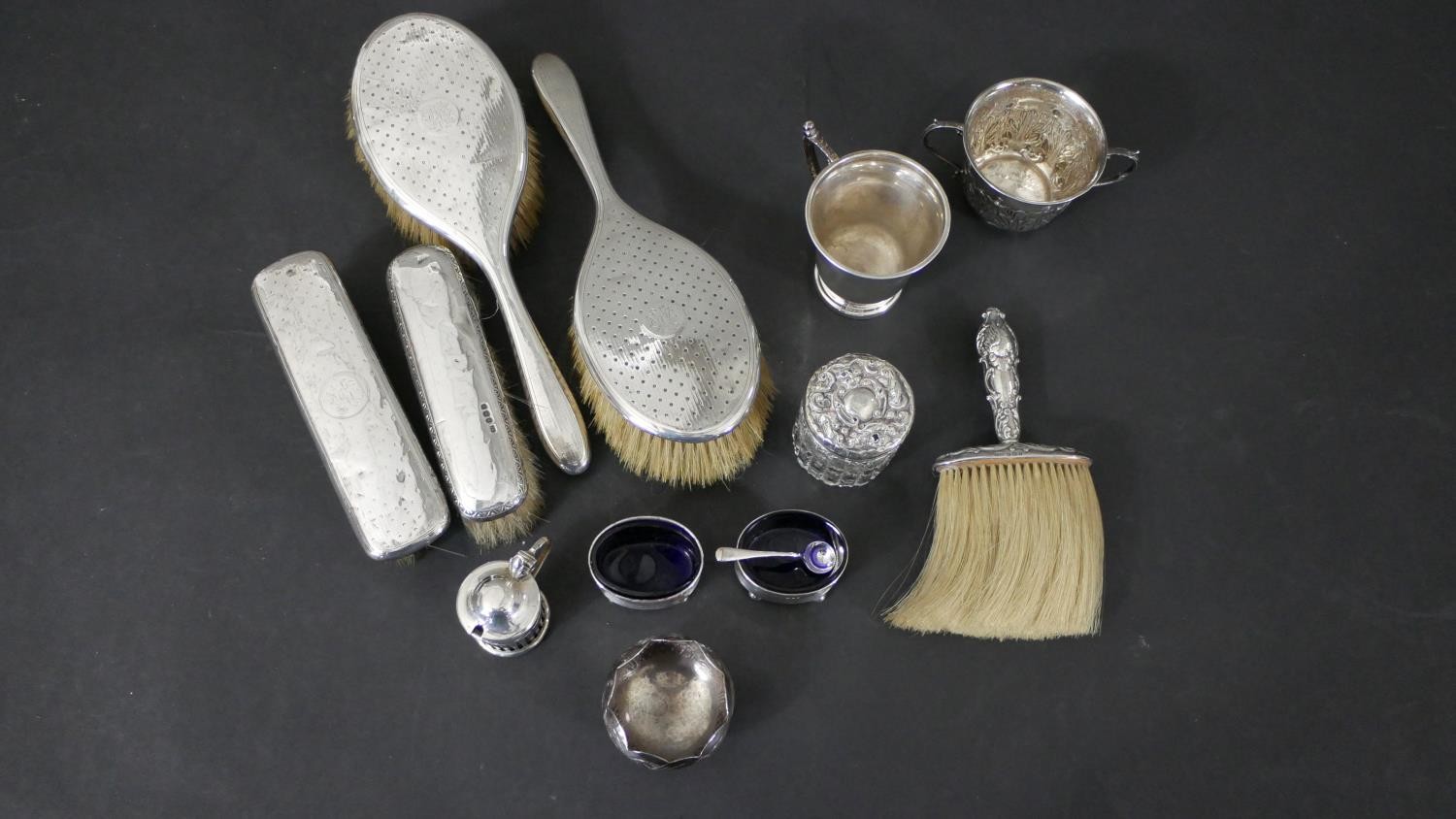 A collection of silver, including a repousse Art Nouveau design twin handled cup, a silver mustard