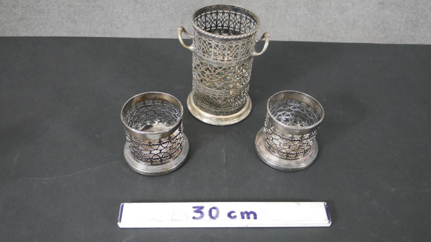 A pair of silver plated pierced design wine coasters and a similar twin handled bottle holder. H. - Image 2 of 7