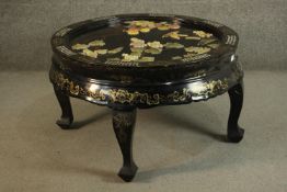 A 20th century Chinese black lacquered circular coffee table, the top inlaid with mother of pearl