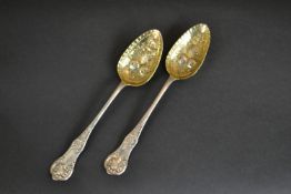 A pair of Victorian James and William Marshall Scottish silver berry spoons with gilded bowls and