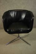 A late 20th century black leather swivel tub chair, bearing a label marked 'Living', on a tubular