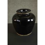 A large provincial Chinese black ware ceramic storage jar with lid. H.25cm.