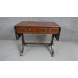 A George III style flame mahogany sofa table, the crossbanded top with drop leaves, over two short