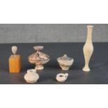 A collection of Roman and ancient Greek pottery, including a miniature clay head on a wooden base,