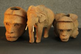 A collection of animals carved from coconut husks, including an elephant and a three headed monkey