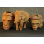 A collection of animals carved from coconut husks, including an elephant and a three headed monkey