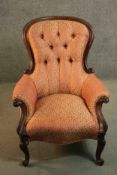 A late 19th century walnut spoon back armchair, upholstered in patterned red and gold fabric with