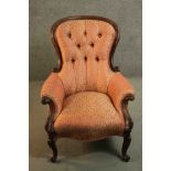 A late 19th century walnut spoon back armchair, upholstered in patterned red and gold fabric with