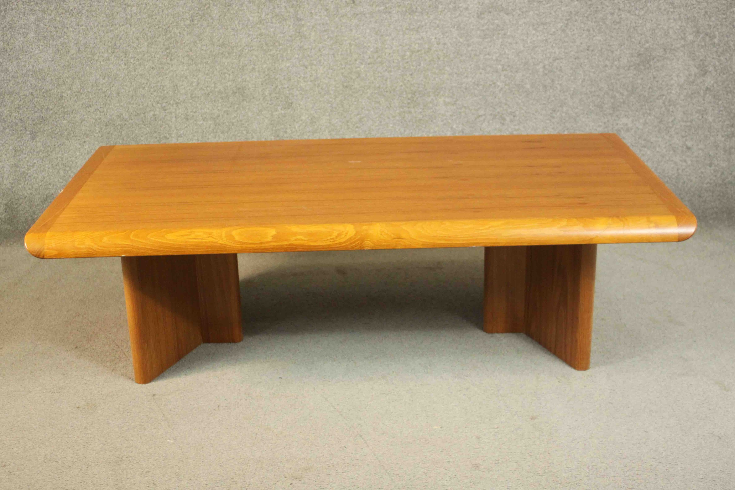 A 1970s vintage Danish teak coffee table on shaped block end supports. H.40 W.135 D.75cm.