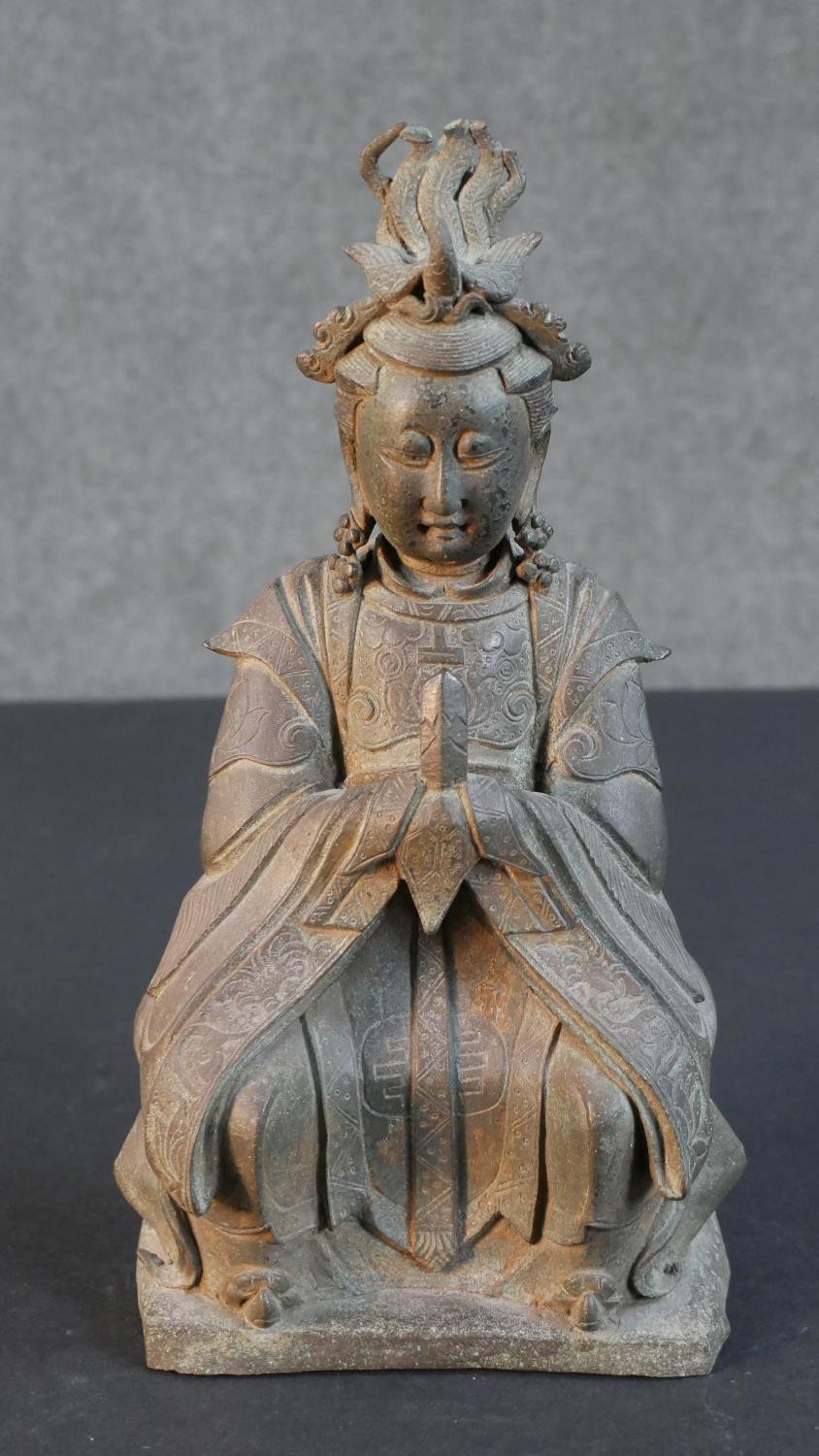 A bronze figure of a seated Chinese deity in traditional robes. H.30 W.17 D.18cm