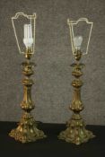 A pair of Continental Rococo Revival brass table lamps, of organic lobed form on a flared quatraform