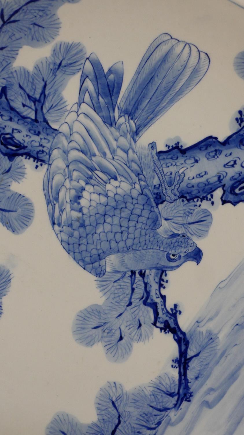 A large Japanese 19th century hand painted blue and white ceramic charger depicting a hawk in a pine - Image 2 of 5