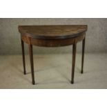 A George III mahogany demi-lune tea table, with a moulded edge and foldover top on square section