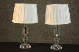 A pair of contemporary cut glass table lamps, with white pleated shades. H.40 Dia.19cm.