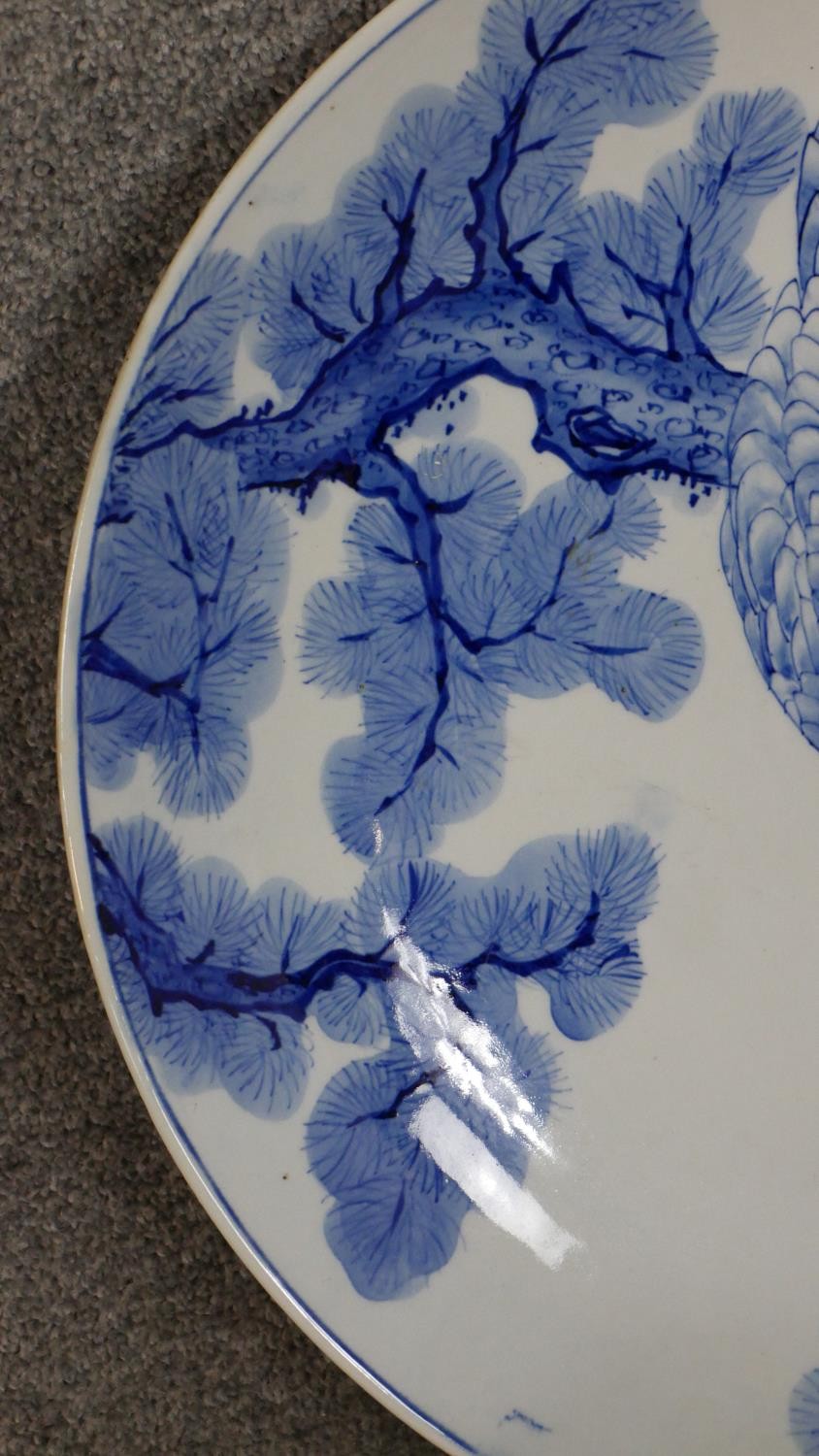 A large Japanese 19th century hand painted blue and white ceramic charger depicting a hawk in a pine - Image 3 of 5