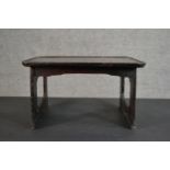 A small ebonised pine table, possibly Korean, with a dished rectangular top on pierced end supports.