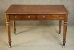 A Victorian mahogany writing table, with a tooled burgundy leather writing insert over two short